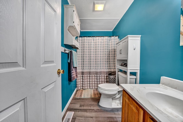 full bathroom with vanity, wood finished floors, a textured ceiling, curtained shower, and toilet