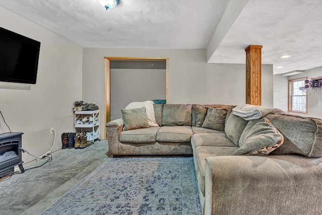 living room with a textured ceiling and a wood stove