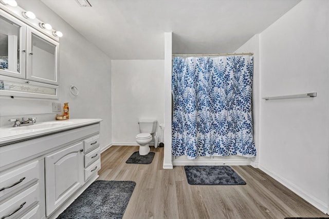 full bath featuring curtained shower, toilet, vanity, and wood finished floors