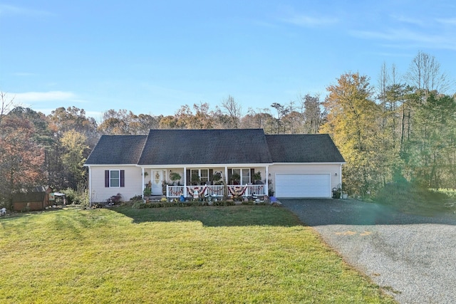 ranch-style home featuring covered porch, a garage, and a front yard