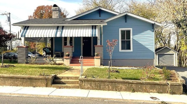 view of front of house featuring an outbuilding, a front lawn, and a garage