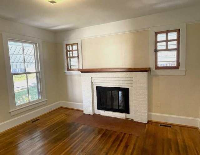 unfurnished living room featuring dark hardwood / wood-style flooring and plenty of natural light