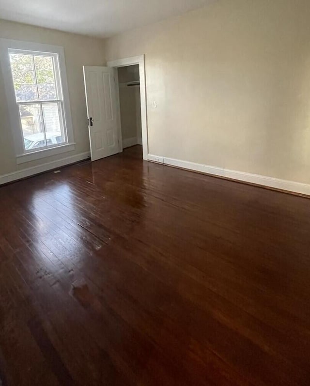 unfurnished room featuring dark wood-type flooring