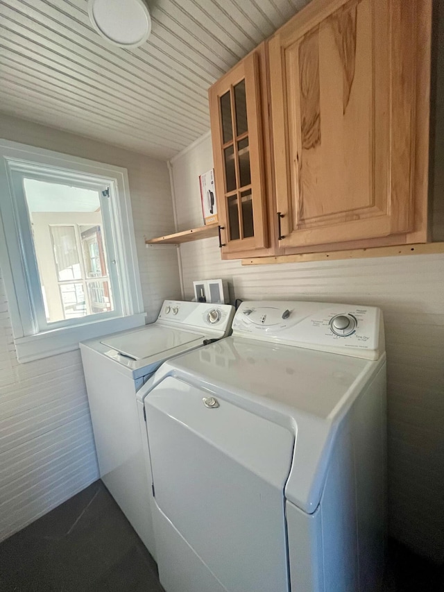 laundry room featuring cabinets, tile walls, and washing machine and clothes dryer