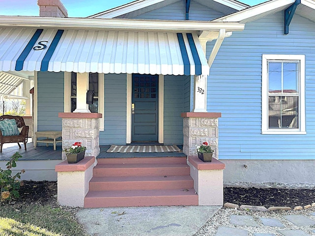 view of exterior entry with a porch