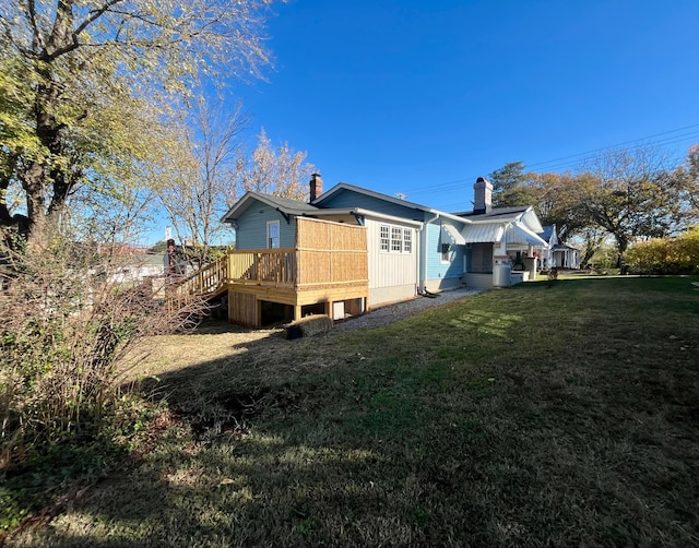 rear view of property with a lawn and a wooden deck