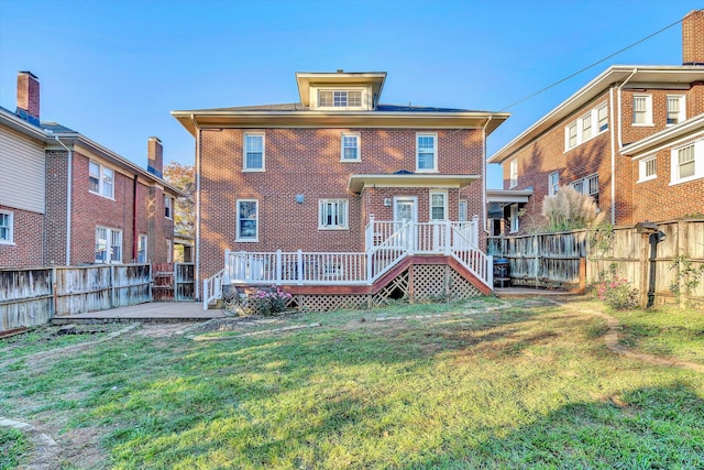 rear view of property featuring a yard and a wooden deck