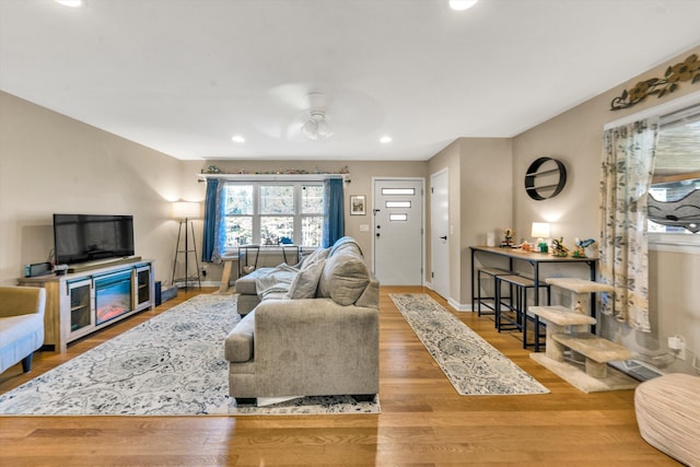 living room featuring hardwood / wood-style floors and ceiling fan