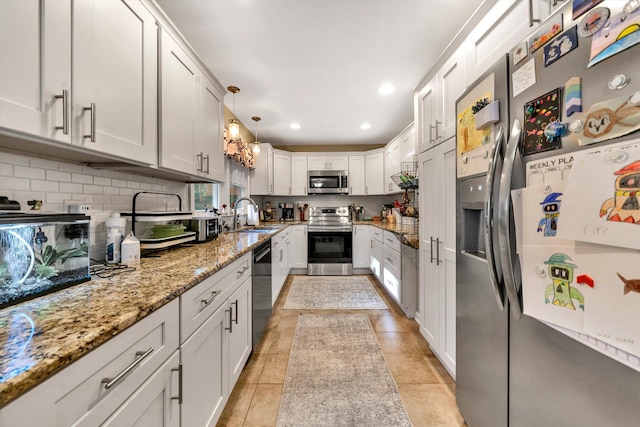 kitchen featuring white cabinetry, decorative light fixtures, and appliances with stainless steel finishes