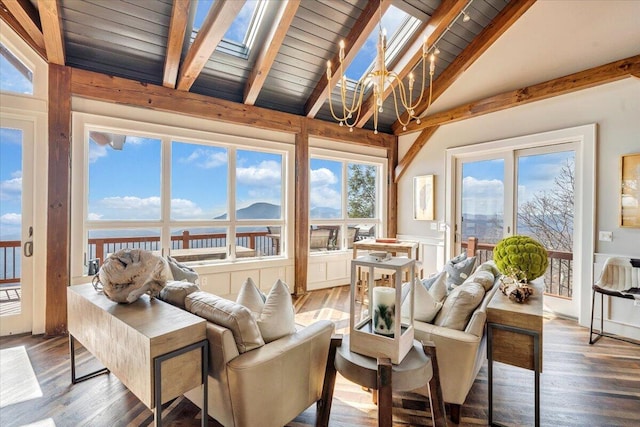 sunroom / solarium featuring lofted ceiling with skylight, plenty of natural light, a water view, and a notable chandelier