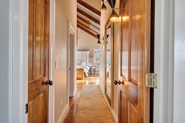 corridor featuring lofted ceiling with beams and wood-type flooring