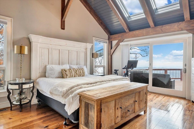 bedroom with access to outside, multiple windows, and a skylight