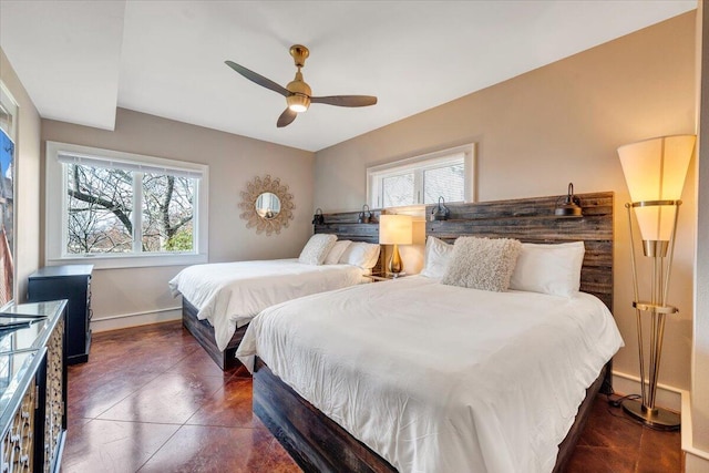 bedroom with multiple windows, ceiling fan, and dark tile patterned flooring