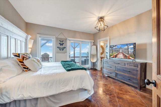 bedroom featuring access to outside and an inviting chandelier