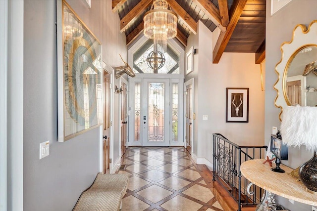 foyer featuring beam ceiling, high vaulted ceiling, wooden ceiling, and a notable chandelier