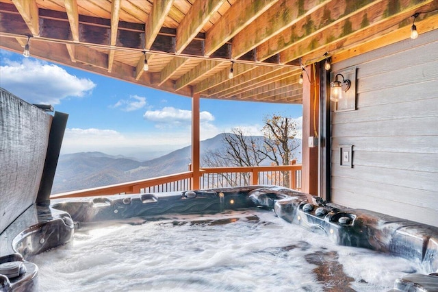 wooden terrace featuring a mountain view and a hot tub