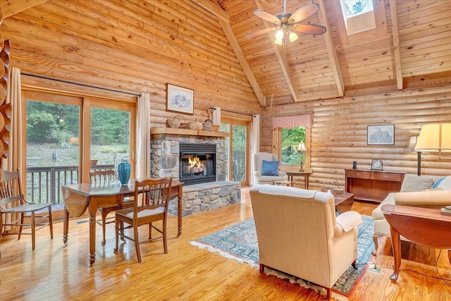 living room with a stone fireplace, high vaulted ceiling, ceiling fan, wooden ceiling, and light wood-type flooring