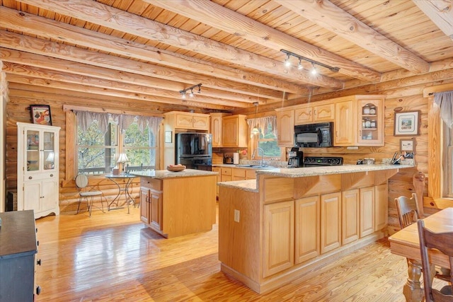 kitchen featuring wood ceiling, a healthy amount of sunlight, a kitchen island, and black appliances