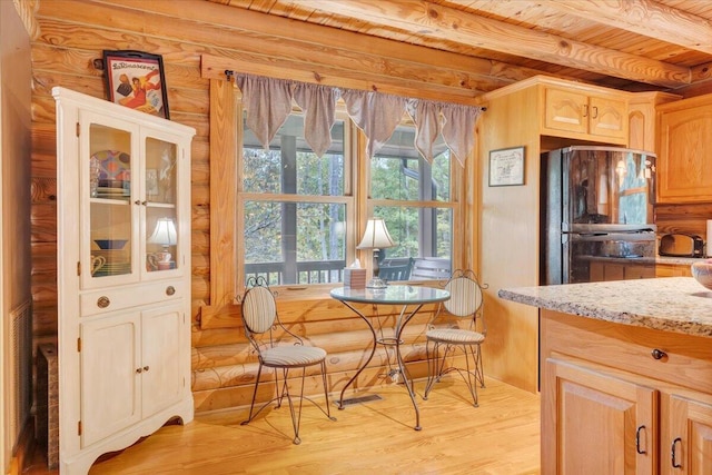 kitchen featuring light stone countertops, black refrigerator, light brown cabinets, and wood ceiling