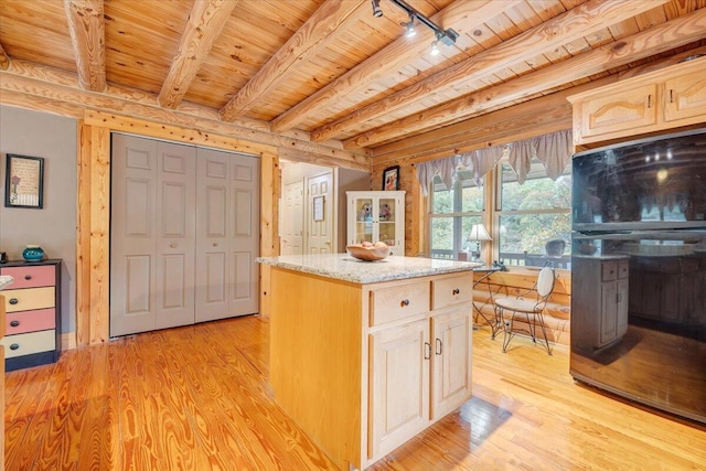 kitchen with beam ceiling, wood ceiling, light hardwood / wood-style flooring, and a center island