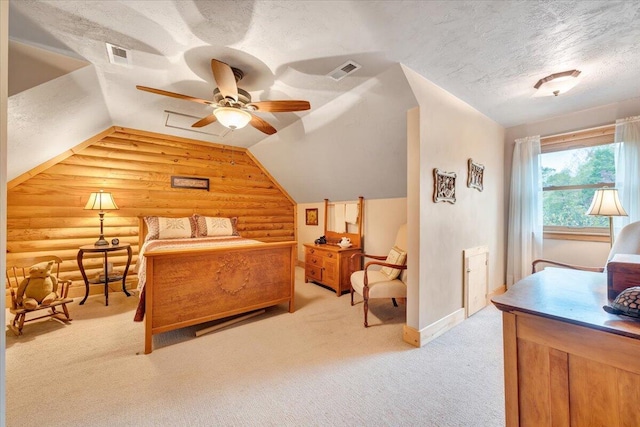 bedroom with lofted ceiling, ceiling fan, rustic walls, a textured ceiling, and light colored carpet