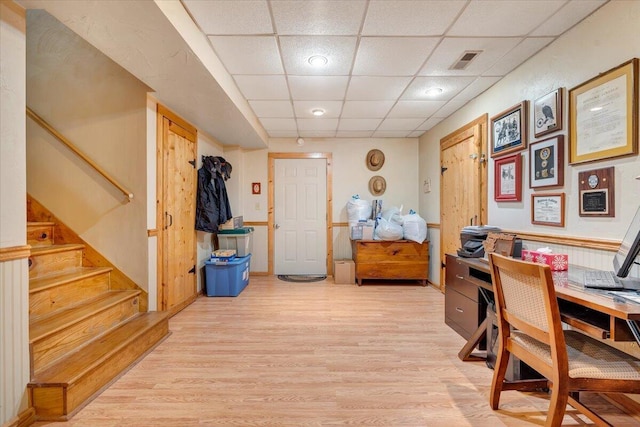 office area with a drop ceiling and light hardwood / wood-style flooring