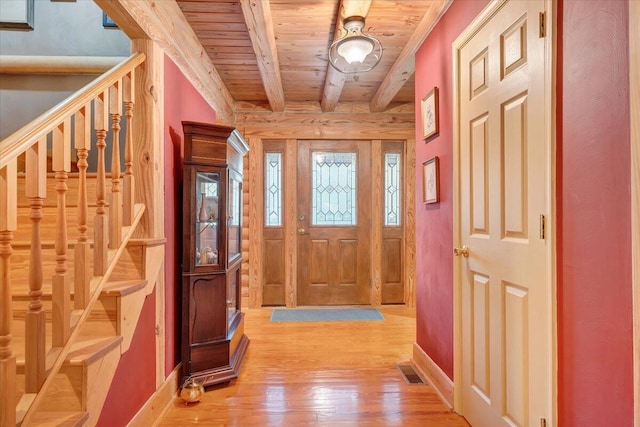 entryway with hardwood / wood-style flooring, wooden ceiling, and beam ceiling