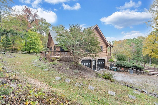 view of side of property with a garage and a deck