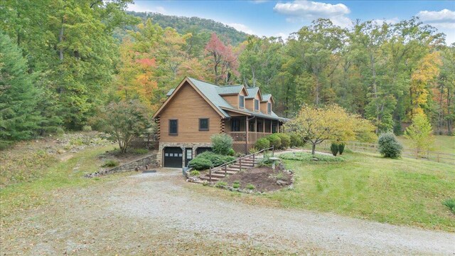 log-style house featuring a garage, a front lawn, and a porch