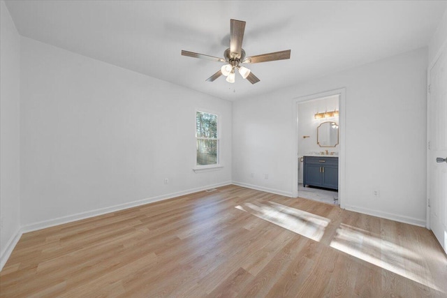 unfurnished bedroom with ensuite bath, ceiling fan, sink, and light wood-type flooring