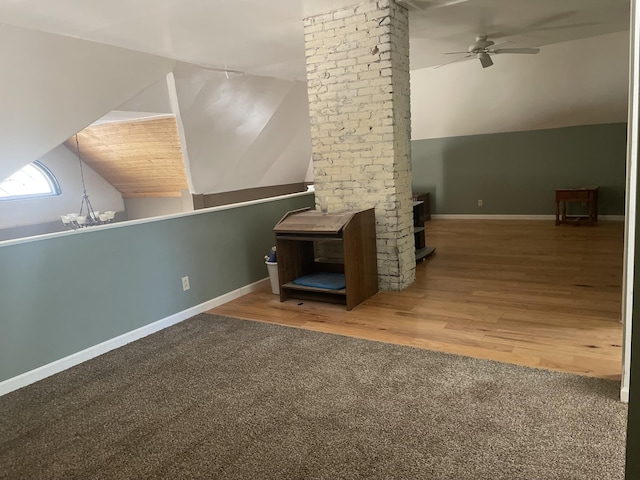 interior space featuring lofted ceiling, ceiling fan, baseboards, and wood finished floors