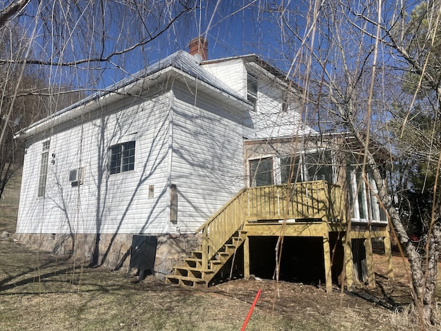 view of home's exterior featuring a chimney, stairway, and a wooden deck