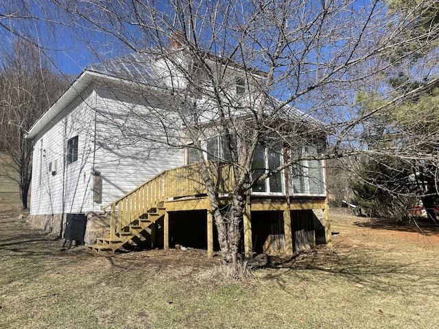 rear view of house with stairway and a lawn