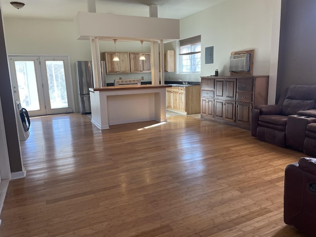 kitchen with light wood-style floors, freestanding refrigerator, open floor plan, and hanging light fixtures