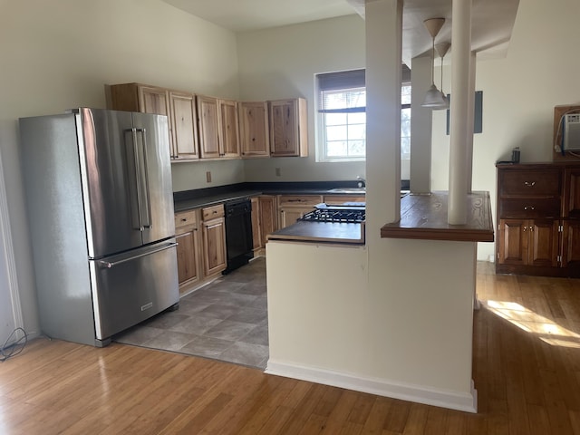 kitchen featuring light wood finished floors, black dishwasher, high end refrigerator, dark countertops, and brown cabinets