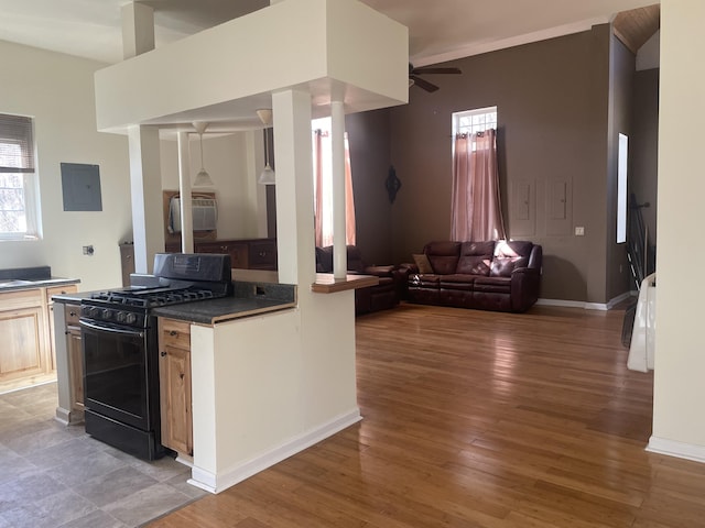 kitchen featuring wood finished floors, open floor plan, black range with gas stovetop, electric panel, and dark countertops