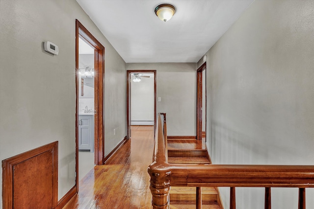 hallway featuring light hardwood / wood-style flooring, a baseboard radiator, and sink