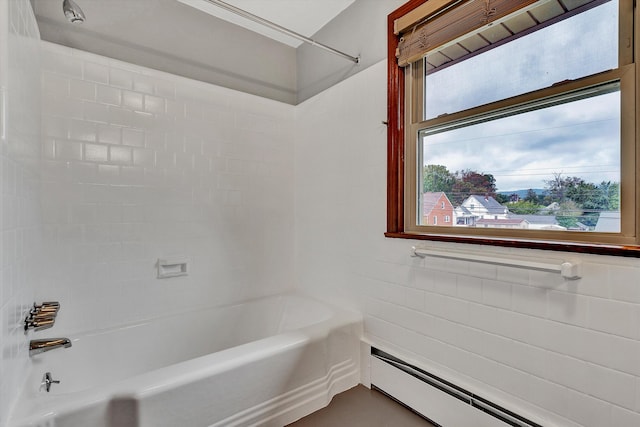 bathroom with washtub / shower combination, baseboard heating, and tile walls