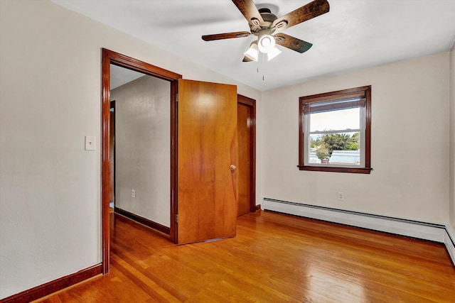 unfurnished bedroom featuring ceiling fan, light hardwood / wood-style floors, and a baseboard heating unit