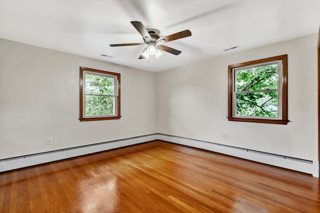 spare room with ceiling fan, hardwood / wood-style floors, and a healthy amount of sunlight