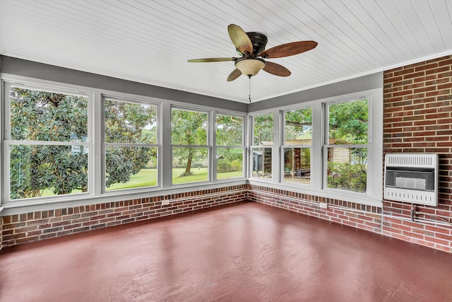 unfurnished sunroom with heating unit, a brick fireplace, and ceiling fan