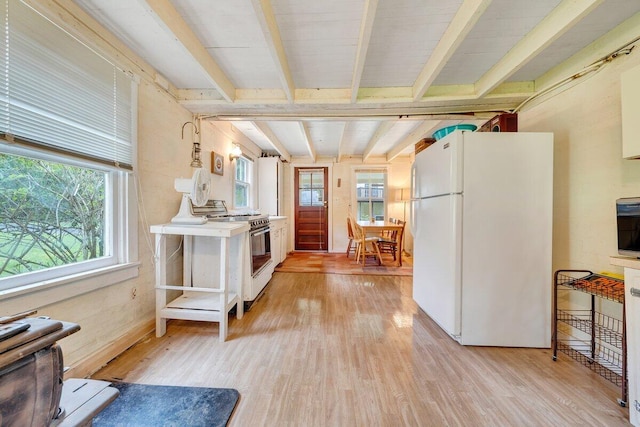 kitchen with beam ceiling, light wood-type flooring, white fridge, and stainless steel range with electric stovetop