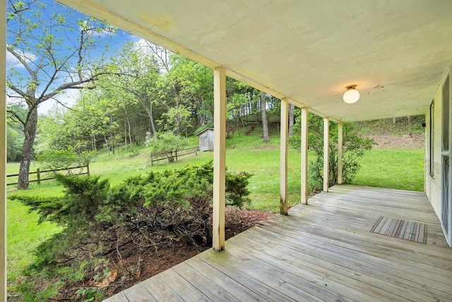 wooden terrace with a storage shed and a yard