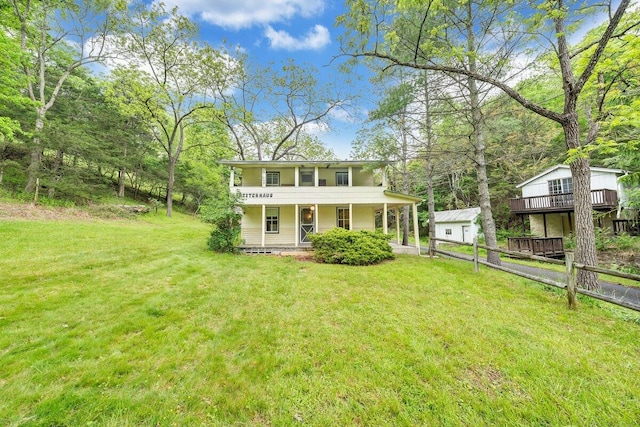 view of front of home with a front yard, a porch, and a balcony