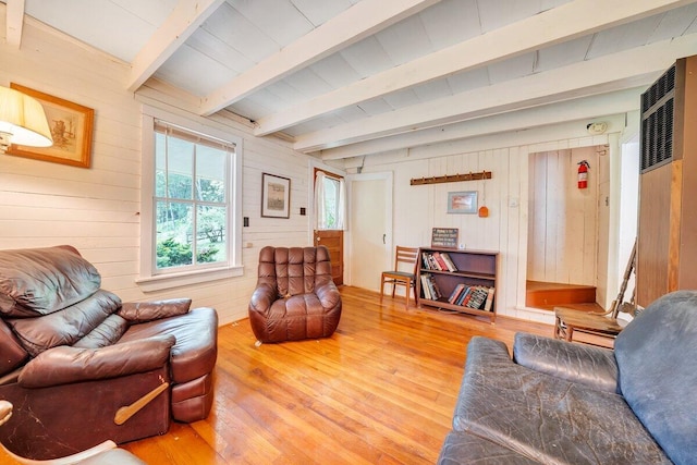 living room featuring wood walls, beamed ceiling, and wood-type flooring