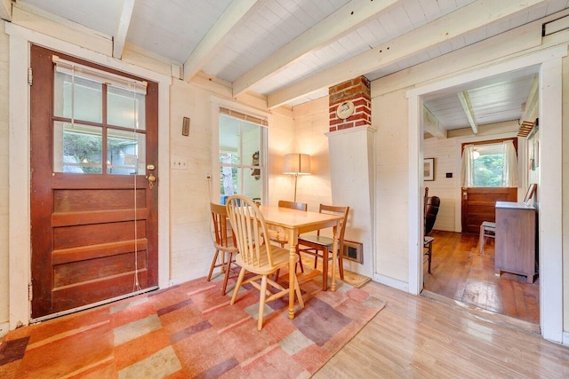 dining room featuring hardwood / wood-style flooring, wooden ceiling, and beamed ceiling