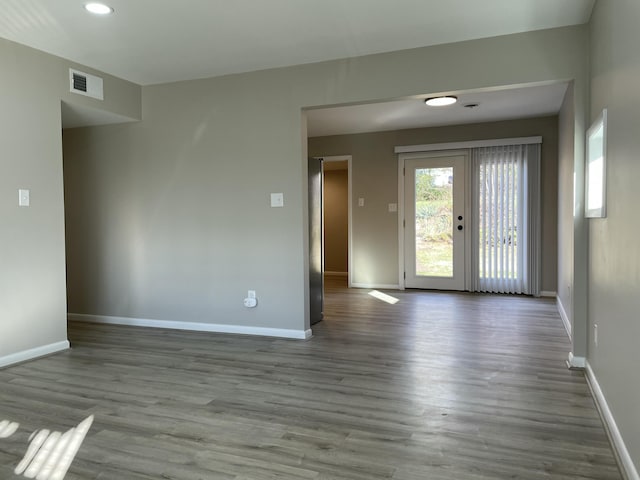 unfurnished room featuring french doors and light hardwood / wood-style flooring