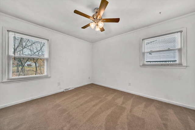 empty room with carpet flooring, crown molding, and ceiling fan