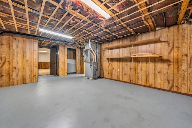 basement with heating unit and wooden walls