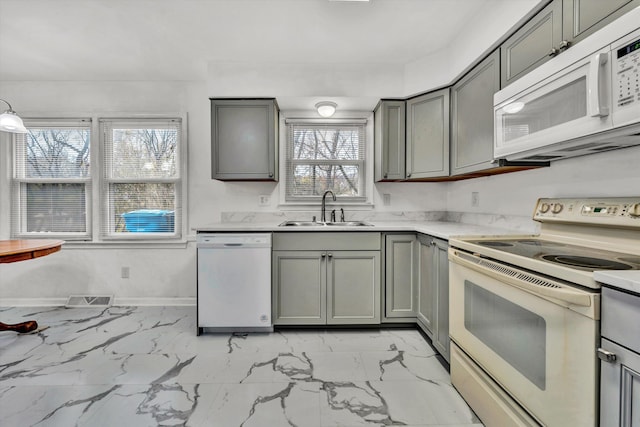 kitchen featuring white appliances, gray cabinets, and sink